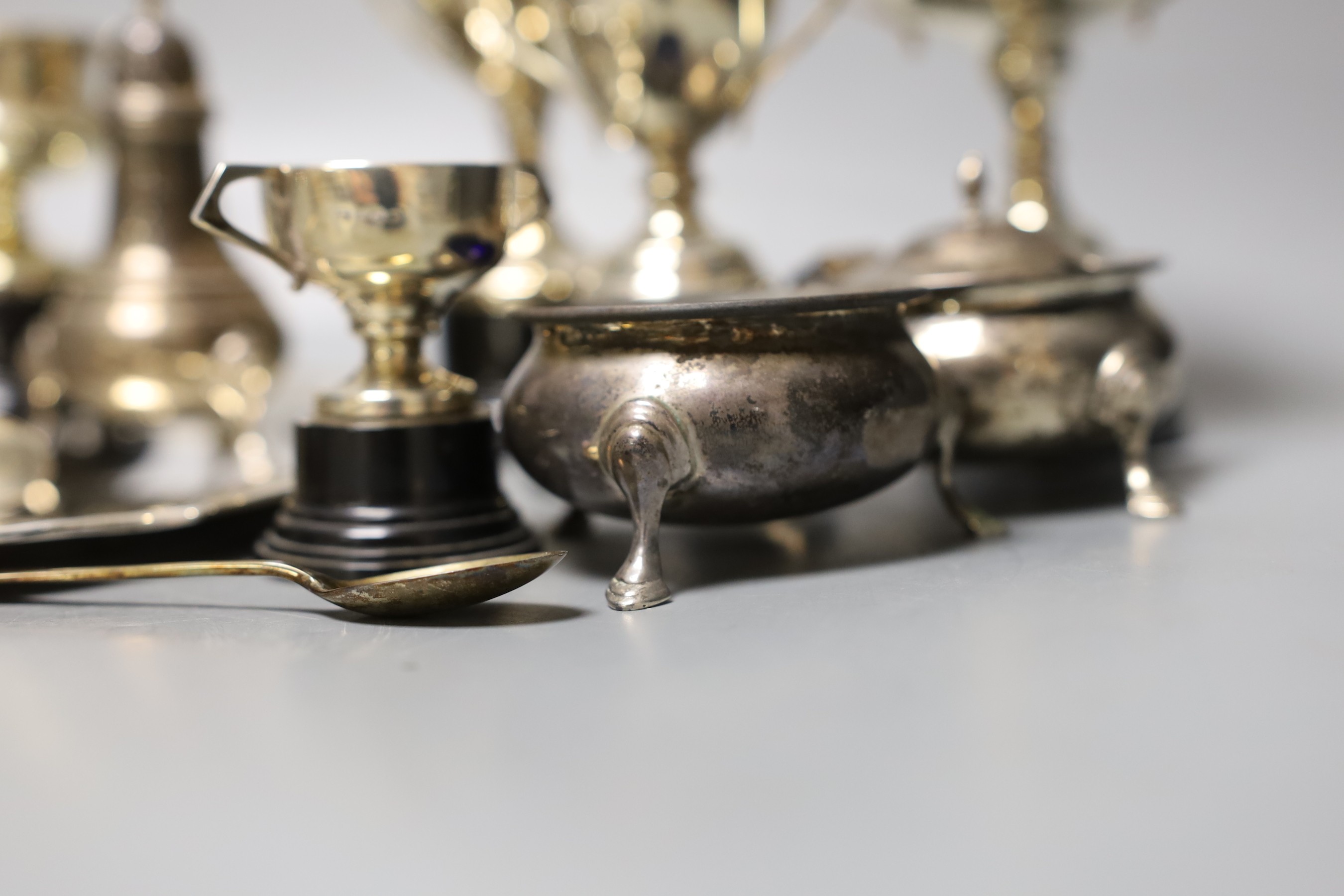 A George V silver salver, a silver tazze, a silver sauceboat, three silver condiments, a silver tea strainer, four items of silver flatware, three small silver trophy cups and two plated cups.